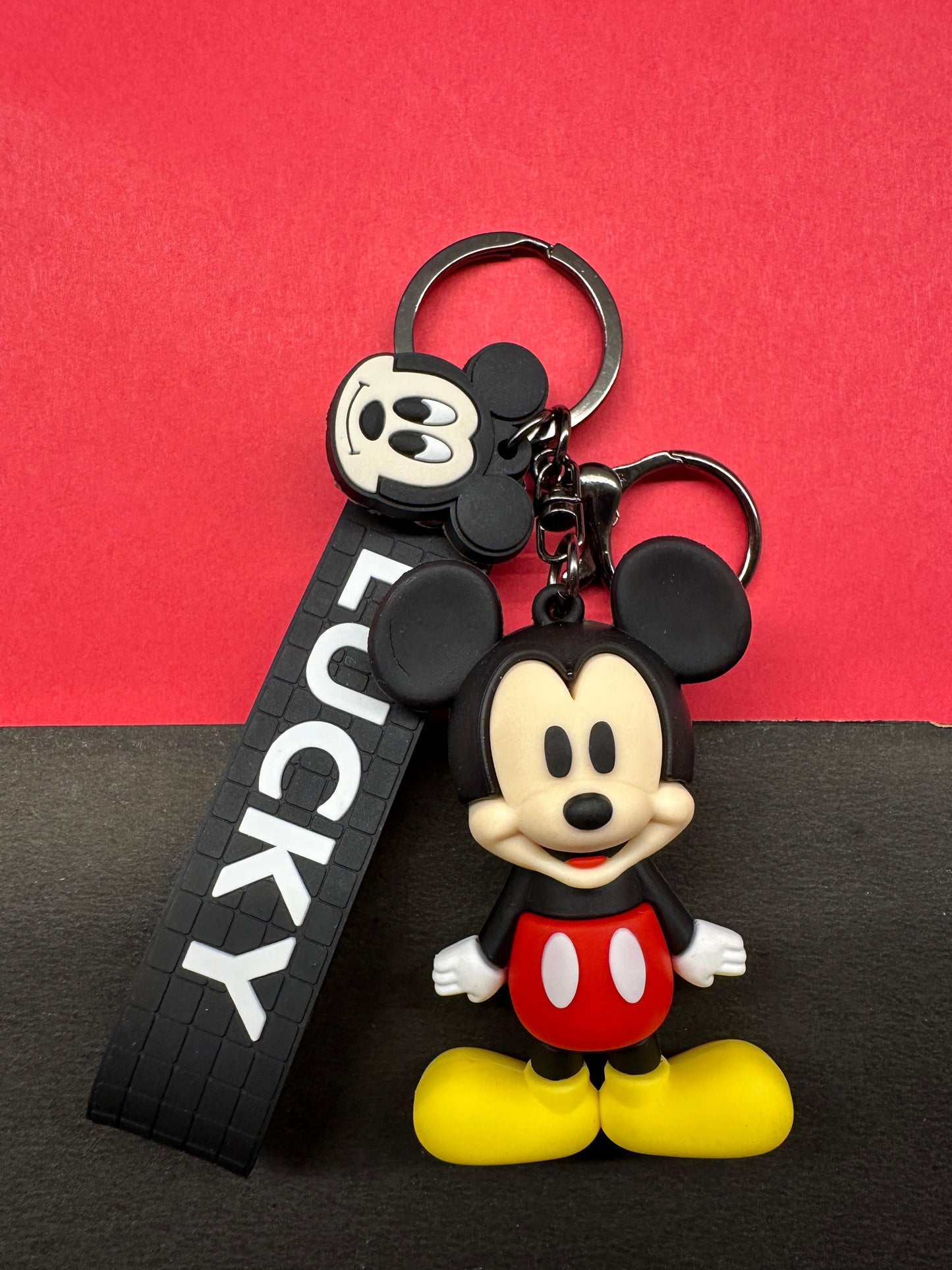 Mickey Mouse keychain with a 'LUCKY' tag on a red and black background