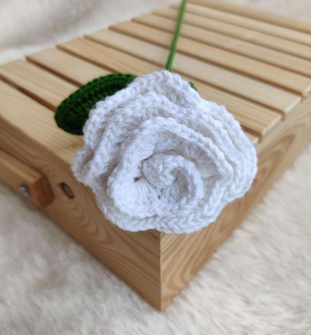 White crocheted flower on a wooden surface