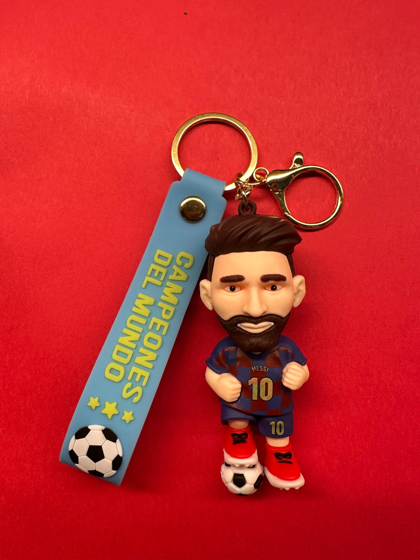 Keychain with a figurine of a soccer player and a blue tag on a red background